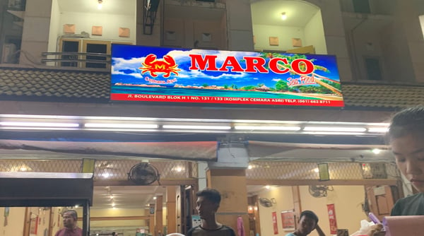 Image shows a restaurant shopfront featuring a "Marco" signboard