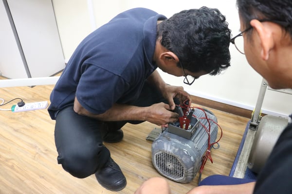 an image showing a technician getting hands-on with electric motor testing