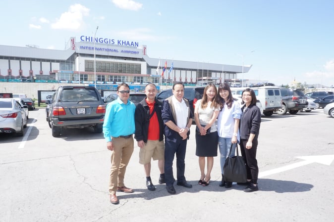 Image shows a group photo of people in front of Chinggis Khan Airport