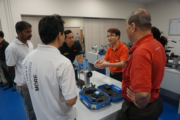 Image shows an SLS engineer explaining shaft alignment to a group of customers