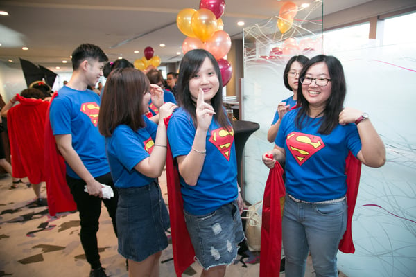 Image shows a group of people dressed in a Superman tee and cape