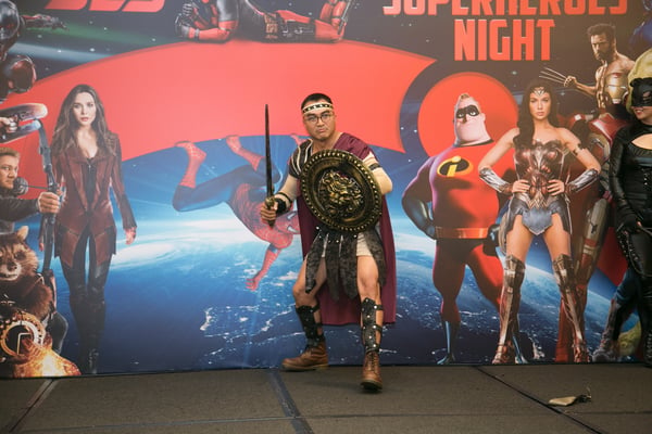 Image shows a man dressed as a Trojan warrior on stage