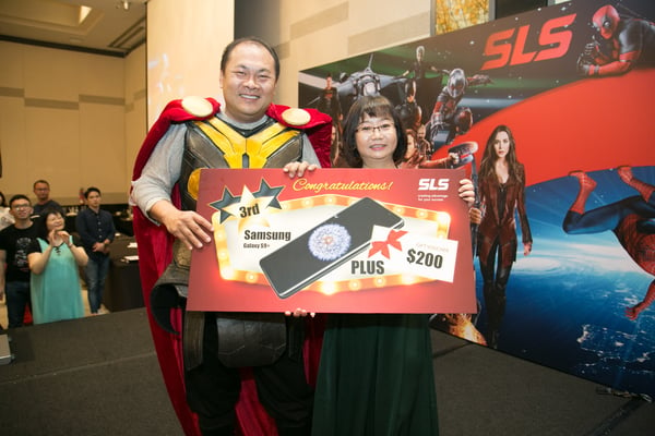 Image shows SLS Group CEO Mr. Roy Tan presenting a prize to a woman