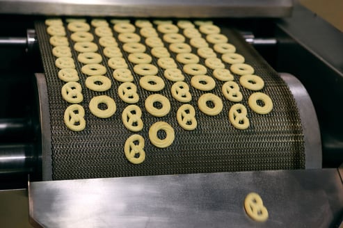 Image shows biscuits being produced on a conveyor belt