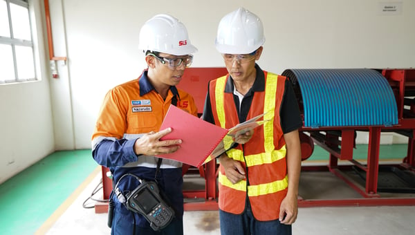 Image shows an SLS engineer and a customer reading a report 