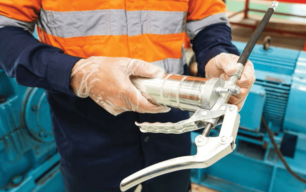 an engineer holding a grease gun